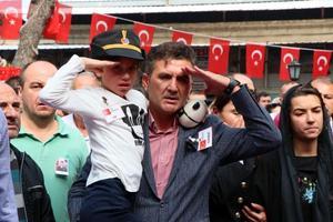 Antalya'da jandarma su altı kurtarma ekibinin dalış eğitiminde rahatsızlanarak şehit olan Jandarma Astsubay Kıdemli Üst Çavuş Mesut Akmeşe, İzmir'in Dikili ilçesinde son yolculuğuna uğurlandı. Çarşı Cami'ne getirilen şehidin naaşını, kızı 8 yaşındaki Hayriye Nil (solda) ve eşi Latife Akmeşe (sağda) asker selamıyla karşıladı.  ( Metin Aydemir - Anadolu Ajansı )